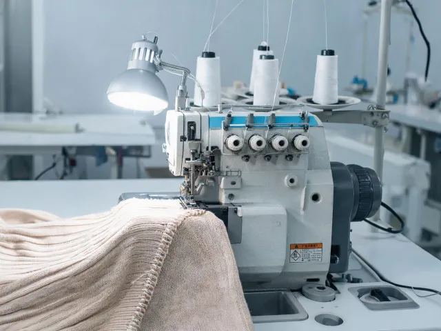 Industrial overlock machine finishing a knit edge